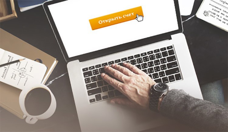 Фото взрослого мужчины сидящего за компьютером, используя ноутбук и клавиатуру.